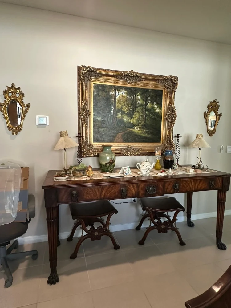 Statement furniture ensemble featuring an ornate carved console table, large framed mirror, and coordinated seating.