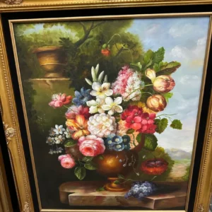 Traditional framed floral still life featuring a full bouquet of colorful flowers in a dark vase.