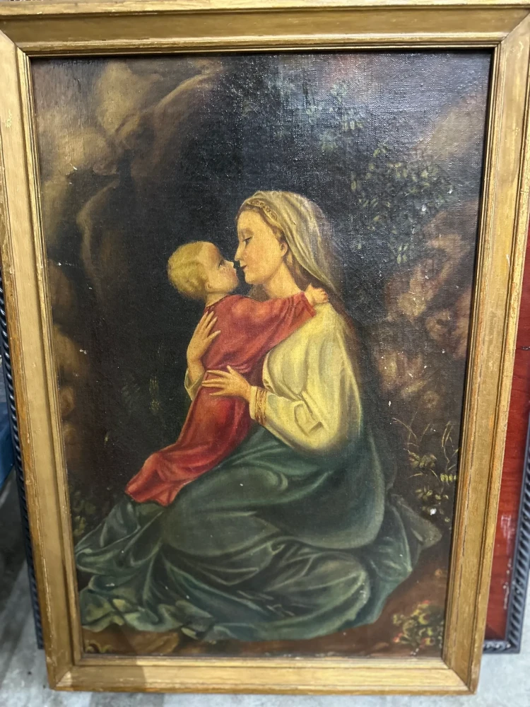 Framed devotional-style portrait of a seated woman in red and gold garments looking upward.