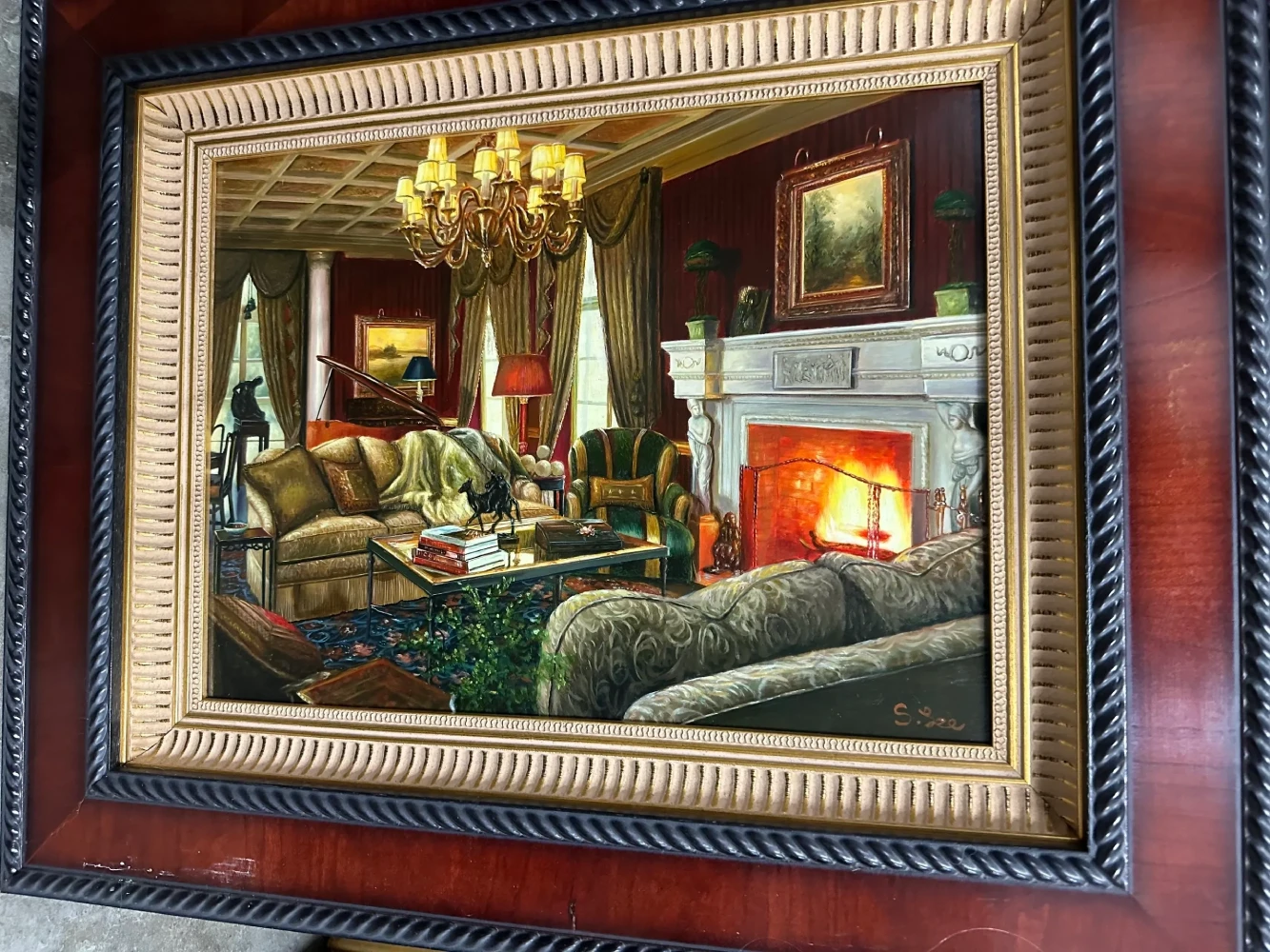 Warm, richly decorated parlor interior with upholstered seating, chandelier, artwork, and a glowing fireplace.