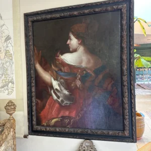Large framed portrait of a woman in profile holding a small object against a dark background.
