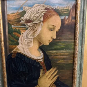 Vertical framed portrait of a young woman in period dress with hands joined in prayer against a landscape background.