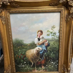 Vertical gilt-framed pastoral scene of a young rider on horseback in a flowering landscape.