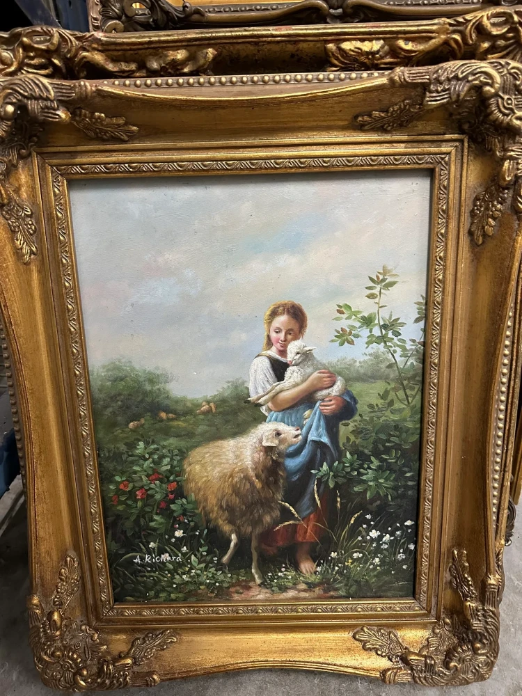 Vertical gilt-framed pastoral scene of a young rider on horseback in a flowering landscape.